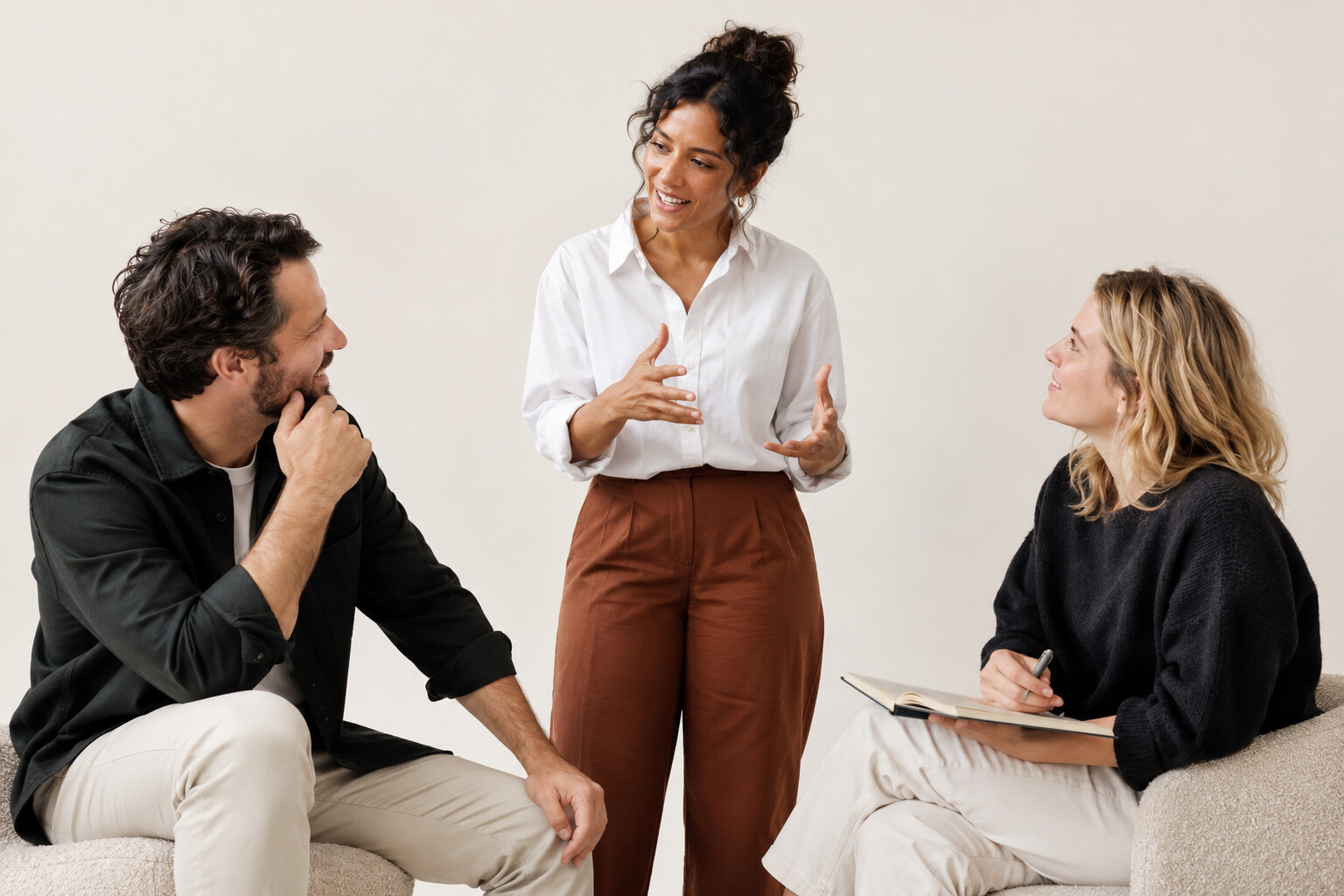 Illustrative studio photograph of a facilitated discussion against a cream backdrop