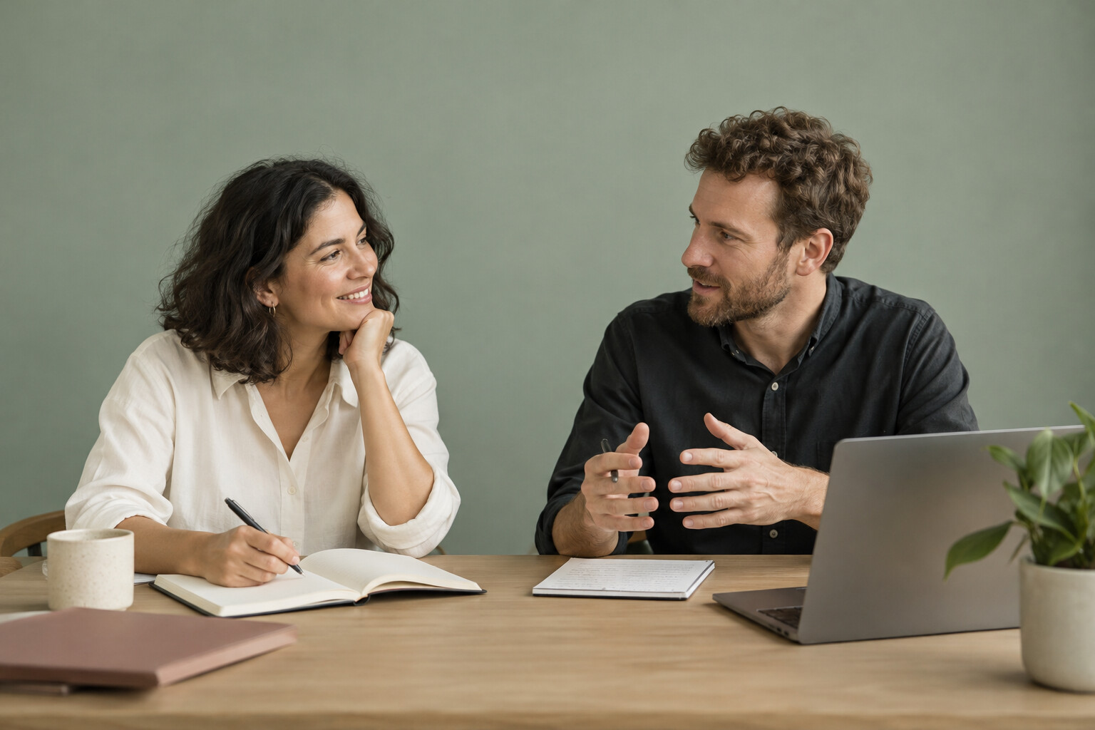 Illustrative studio photograph of professionals collaborating against a sage backdrop